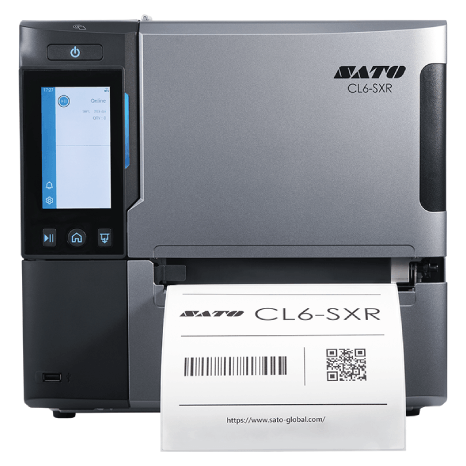 A silver and black SATO CL4-SXR industrial label printer with a front display screen and a white label being printed, shown on a plain white background.