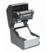 This image provides a visual representation of the SATO CT4-LX Thermal Transfer Printer. It showcases the printer's design, layout, and key features, making it accessible to individuals with visual impairments. The image offers a clear view of the printer's external appearance, including its control panel, label feed mechanism, and connectivity ports. It serves as a reference for those who may need to identify the SATO CT4-LX Thermal Transfer Printer based on its visual characteristics.